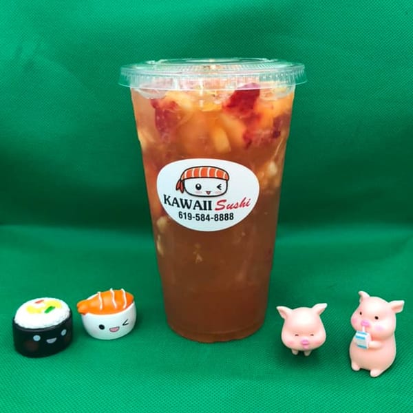 Kawaii Sushi drink with fruit pieces, two sushi figurines, and two pig figurines on a green background.