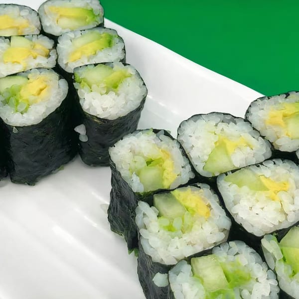 Platter of Kawaii Sushi rolls with avocado and egg, presented on a white plate.